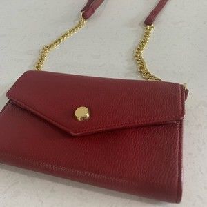 Red leather Stella & Max crossbody purse with gold toned chain strap.